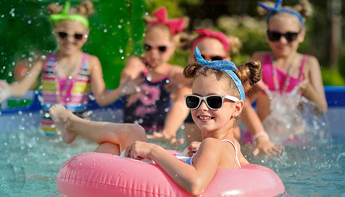 Kids are having fun and splashing at a pool party.