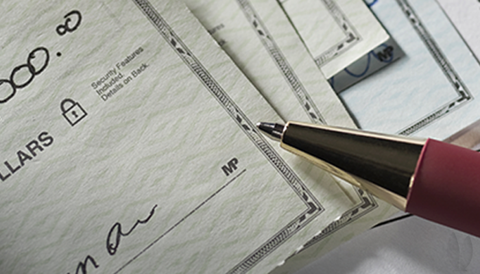 A stack of checked have been signed with a pen.