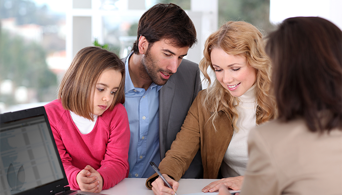 A family is together while signing a contract.