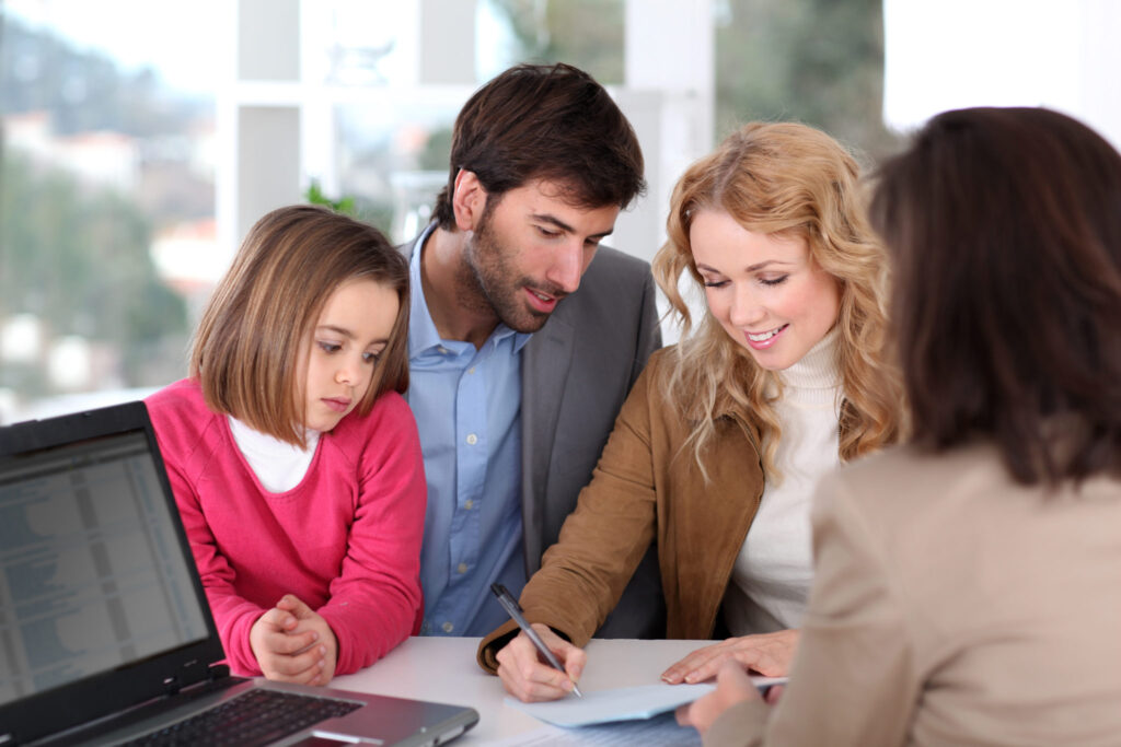 A family is together while signing a contact.