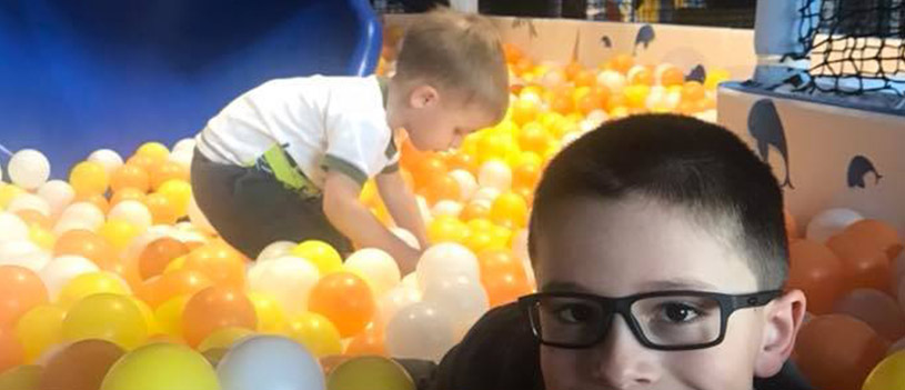 Two kids playing in a ball pit.