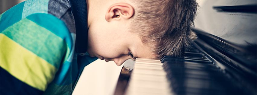 A frustrated kid put down his head during piano lessons.