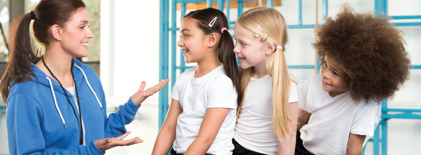 A gym coach inspiring young students to love gymnastics.