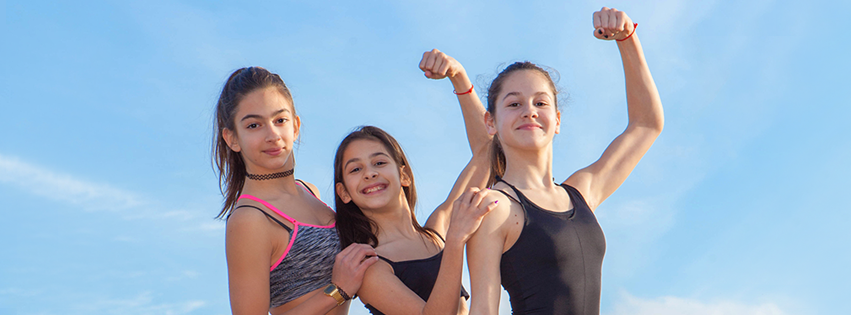 Three girl gymnasts flexing their muscles.