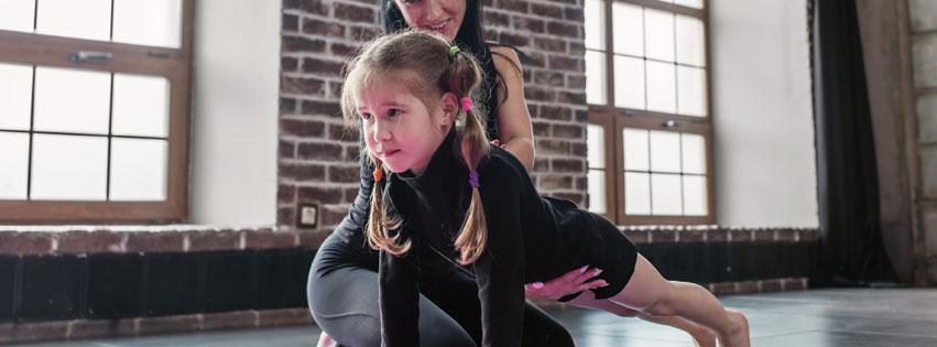 Gymnastics student with her coach and tips on how to have a clear vision for a Children's Gym