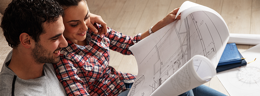 A couple looking at the blueprint schematics of their home.