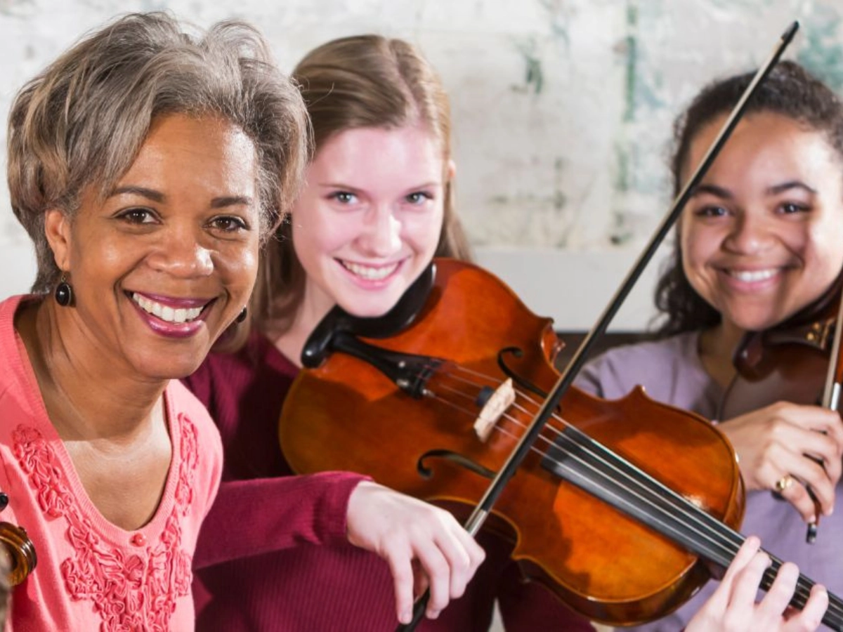 Music teacher smiles with students.