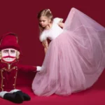 girl in dance costume with doll