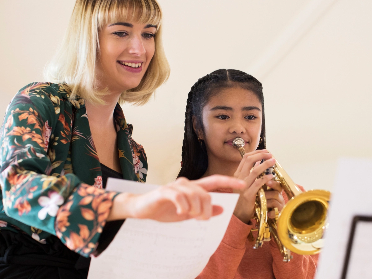 girl playing trumpet with teacher