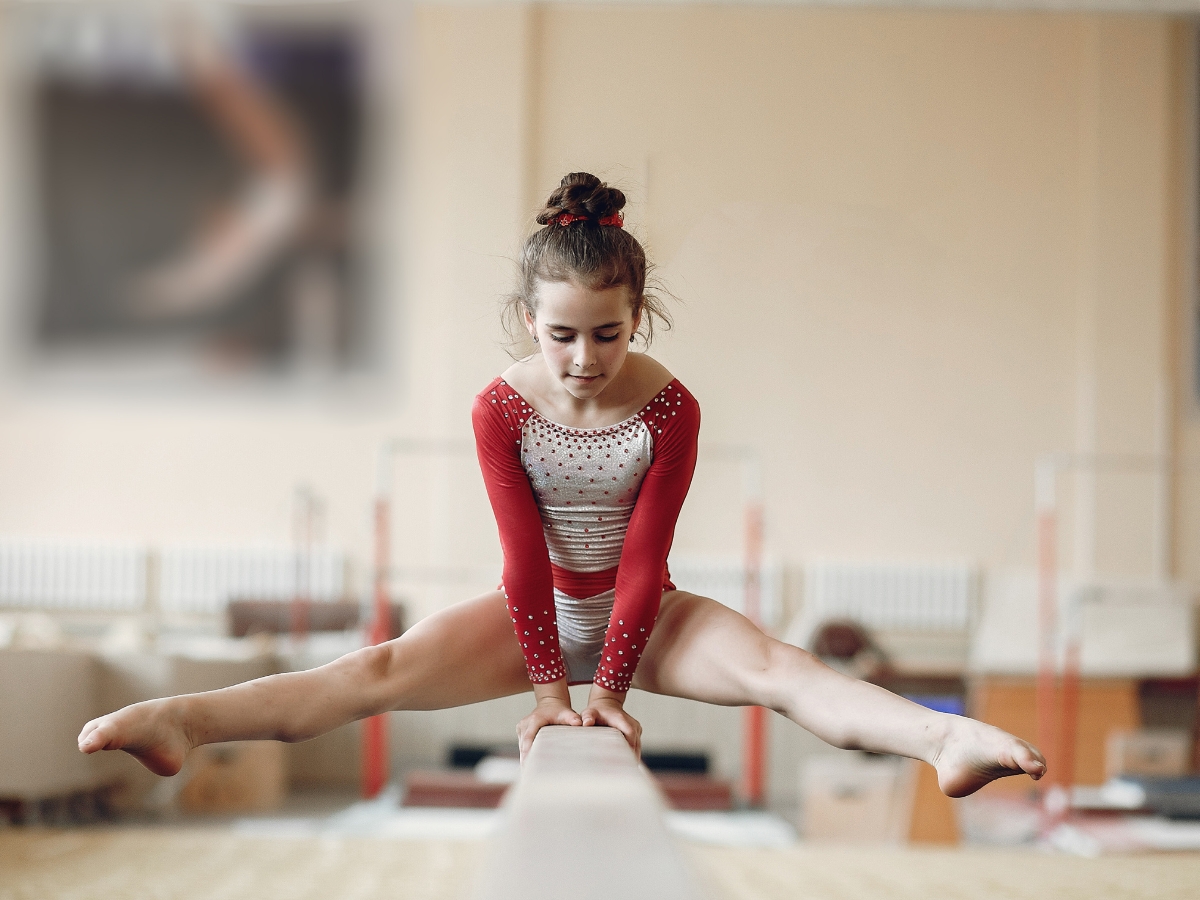 Young gymnast balances on a beam