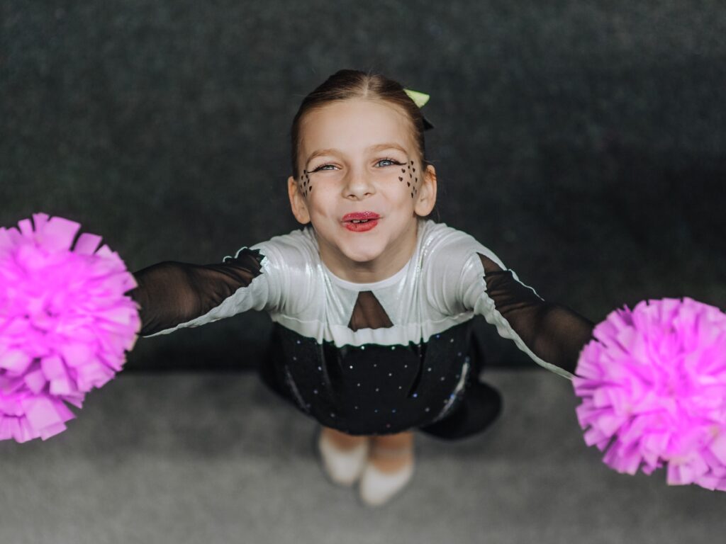 Cheerleader looks up and camera and smiles