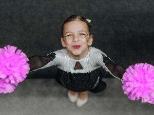 Cheerleader looks up and camera and smiles